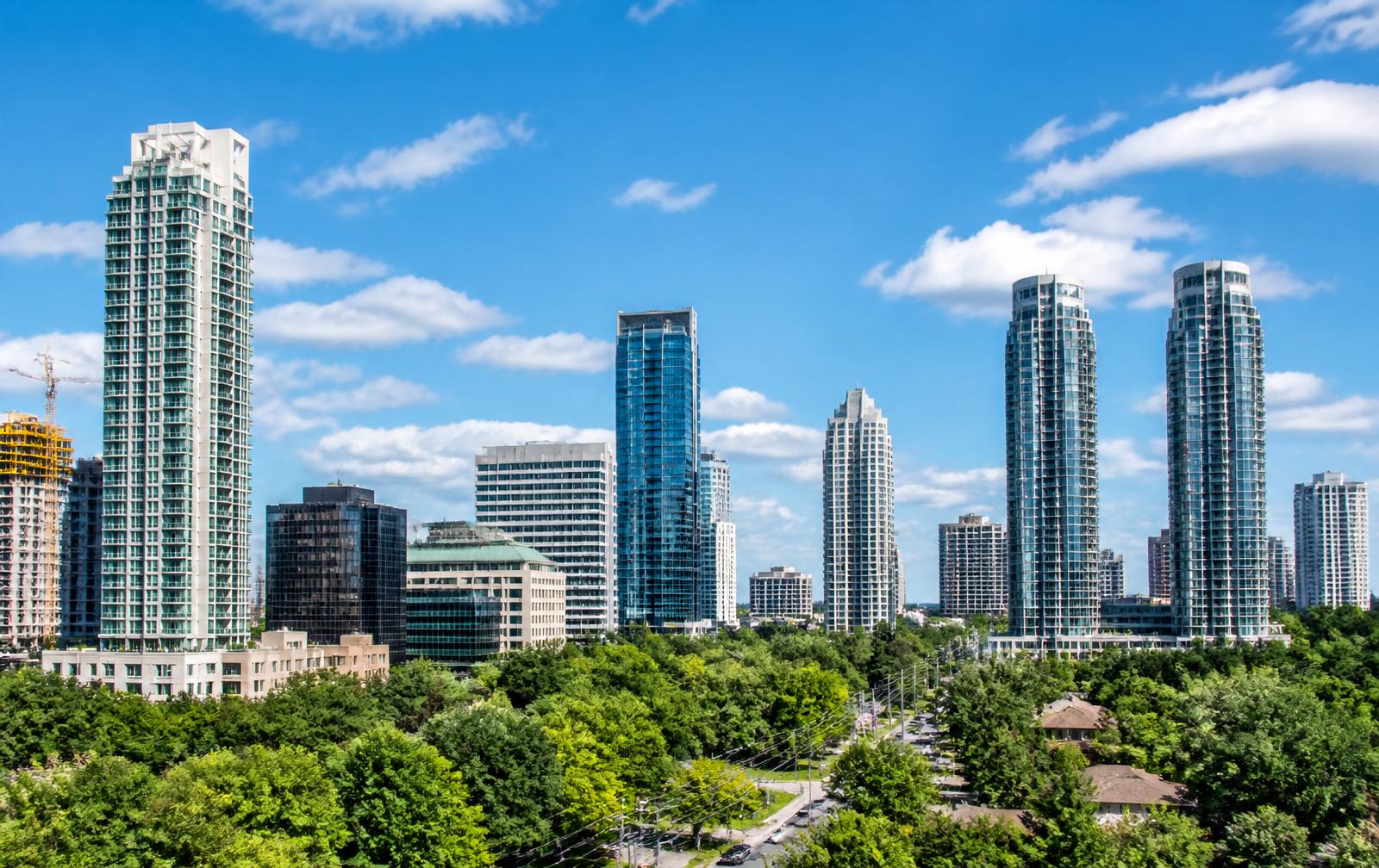 North York skyline on a sunny summer day with modern condo towers and green trees